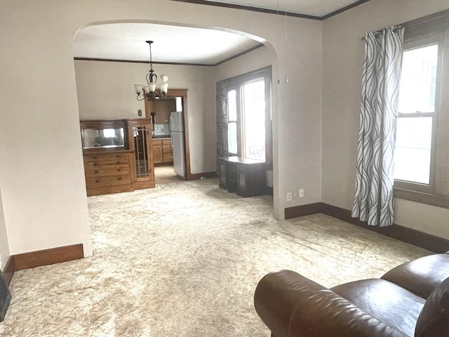 living room with a notable chandelier, crown molding, and carpet floors