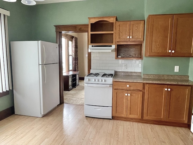 kitchen featuring backsplash, white appliances, and light hardwood / wood-style flooring