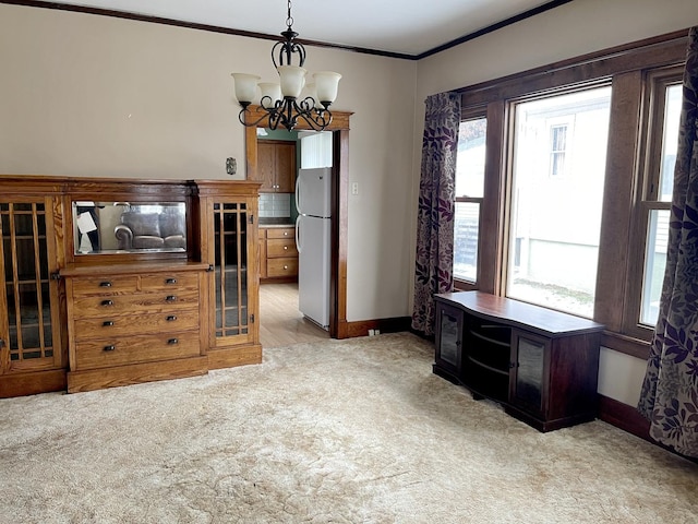 carpeted dining room featuring ornamental molding and a chandelier