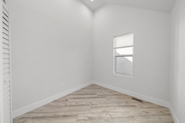 empty room featuring lofted ceiling and light wood-type flooring