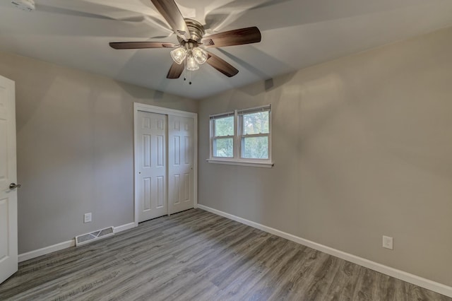 unfurnished bedroom featuring a closet, light hardwood / wood-style flooring, and ceiling fan