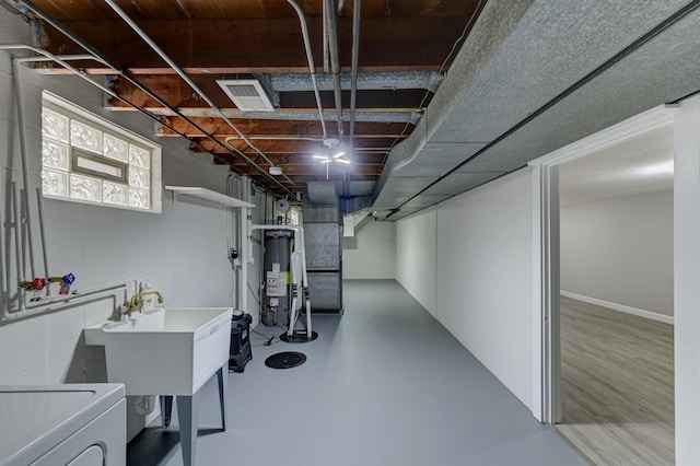 basement featuring sink, washer / clothes dryer, and water heater