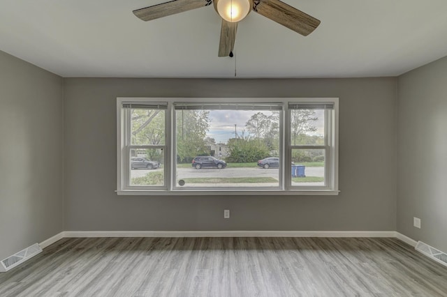 empty room with ceiling fan and light wood-type flooring