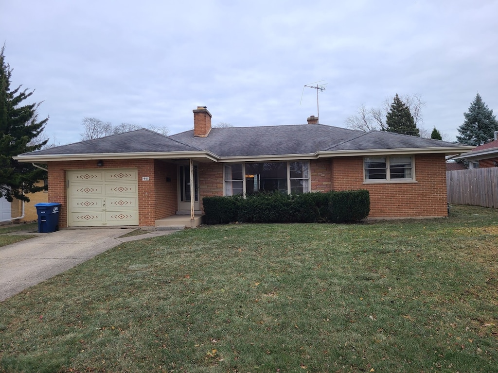 ranch-style home with a garage and a front lawn