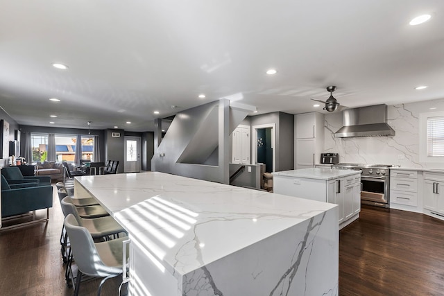 111 N Kenilworth Ave, Mount Prospect, IL 60056 - kitchen with wall chimney range hood, open floor plan, stainless steel range, a kitchen island, and recessed lighting