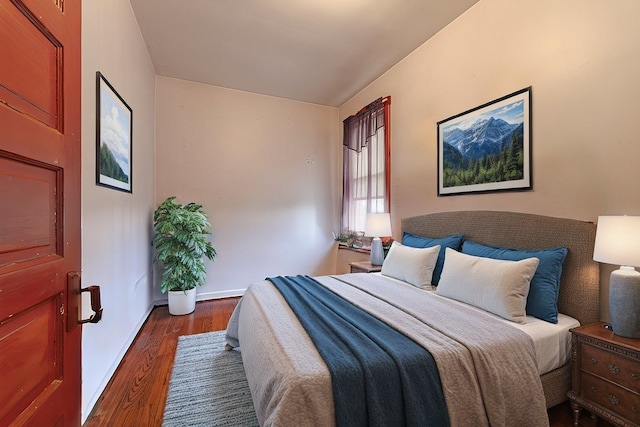 bedroom featuring dark wood-type flooring and lofted ceiling