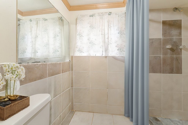 bathroom featuring toilet, crown molding, and tile walls