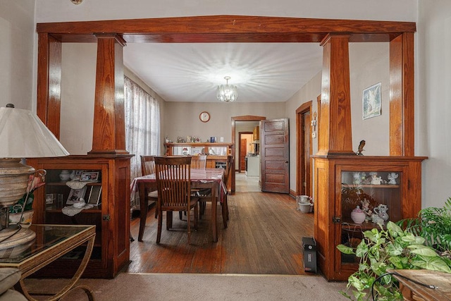 dining room featuring dark carpet and an inviting chandelier