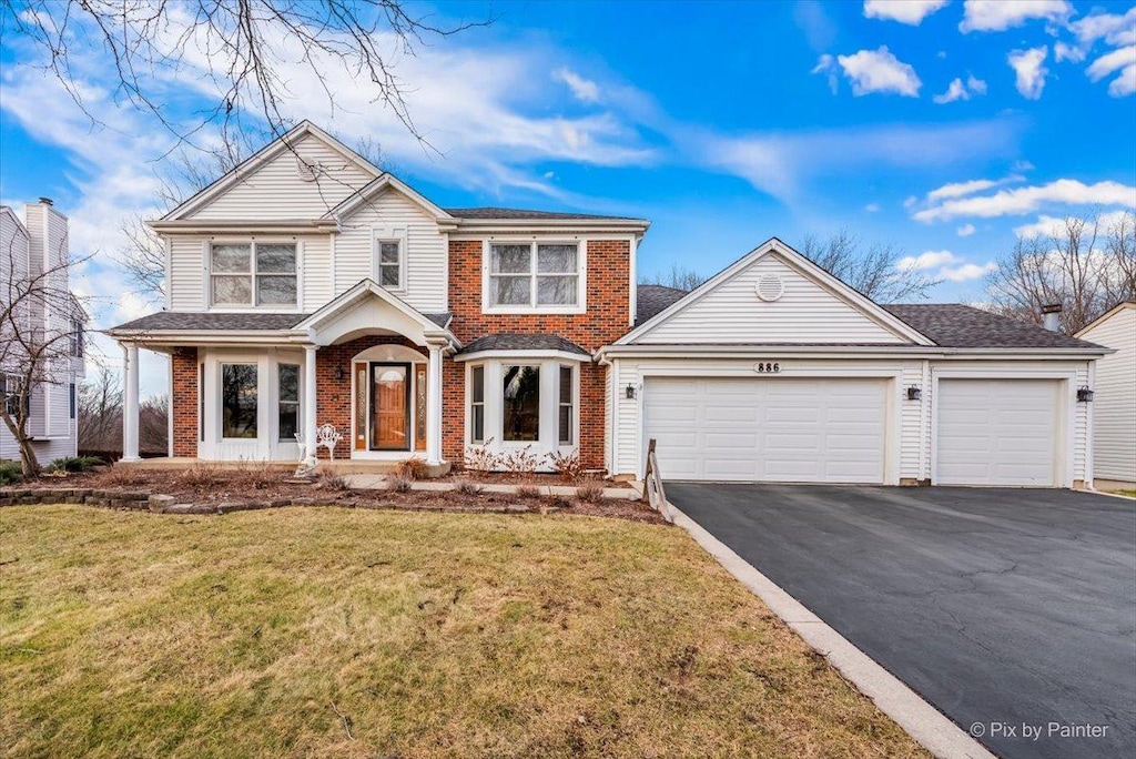 view of property with a front lawn and a garage