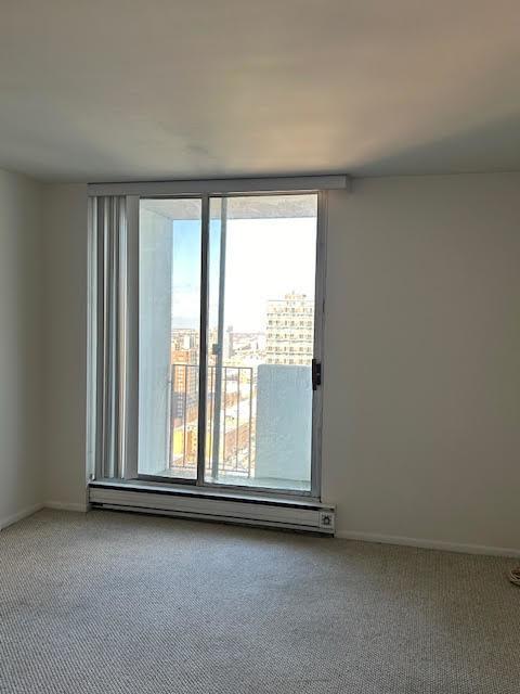 unfurnished room featuring a baseboard radiator and carpet