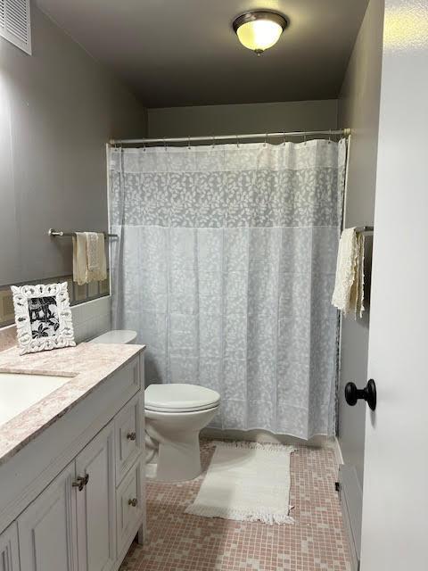 bathroom featuring tile patterned flooring, vanity, and toilet