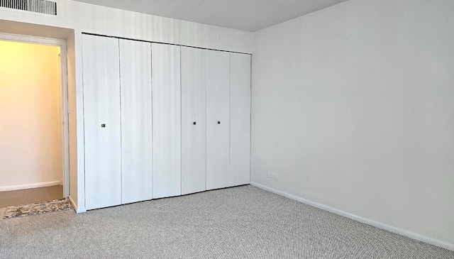 unfurnished bedroom featuring carpet floors and a closet