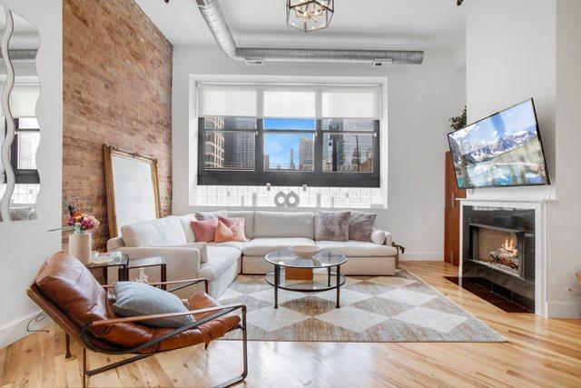 living room with brick wall and hardwood / wood-style flooring