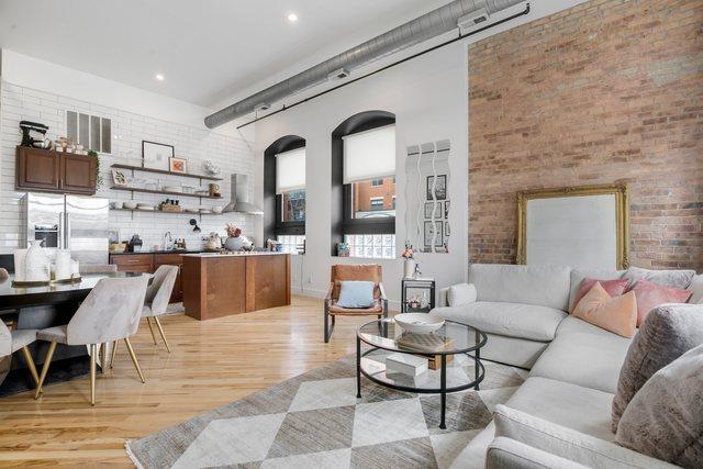 living room featuring light hardwood / wood-style floors, a high ceiling, and brick wall