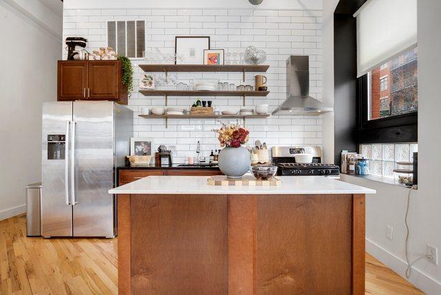 kitchen featuring sink, wall chimney exhaust hood, stainless steel appliances, light hardwood / wood-style floors, and decorative backsplash