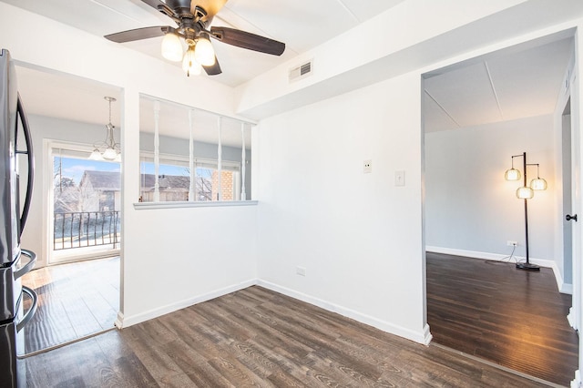 unfurnished room with ceiling fan with notable chandelier and dark hardwood / wood-style floors