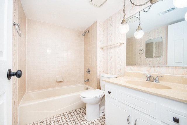 full bathroom featuring vanity, toilet, and tiled shower / bath