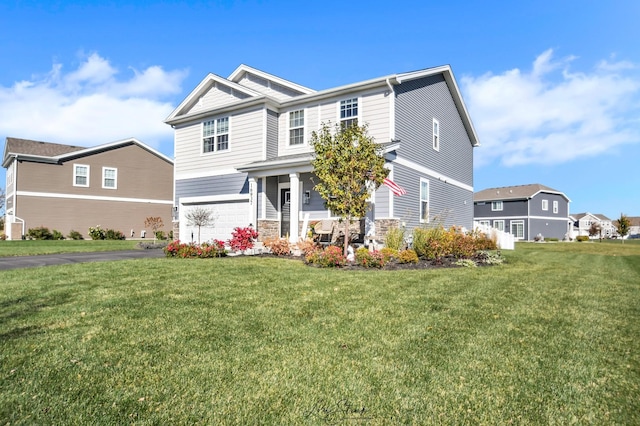 view of front of house featuring a porch, a front yard, and a garage