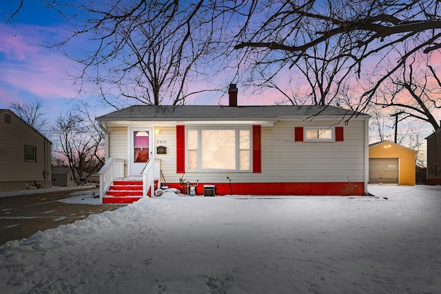 view of front of house with a garage and an outbuilding