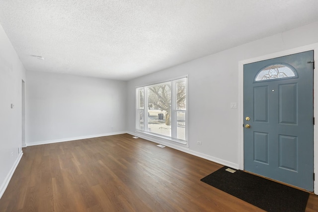 foyer featuring dark hardwood / wood-style flooring and a textured ceiling