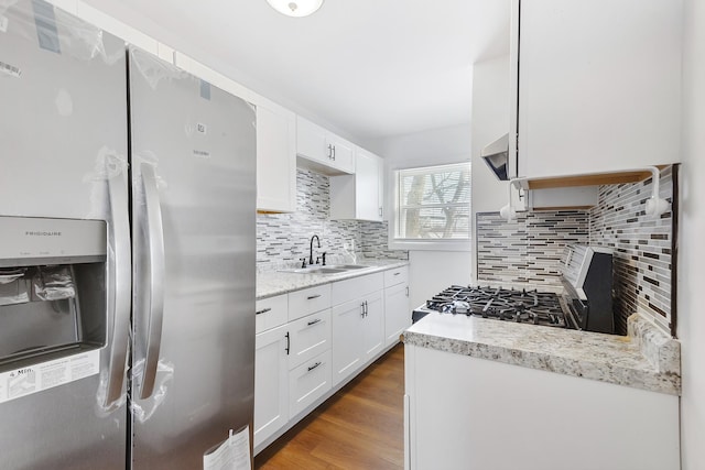 kitchen with decorative backsplash, stainless steel appliances, white cabinetry, and sink