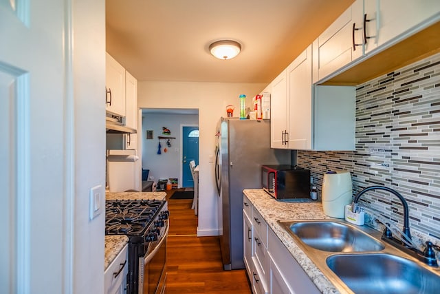 kitchen featuring white cabinets, ventilation hood, stainless steel range with gas cooktop, sink, and decorative backsplash