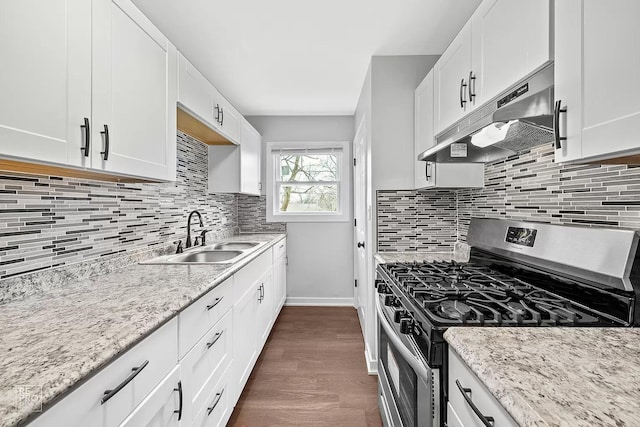 kitchen featuring stainless steel gas range oven, decorative backsplash, and white cabinets