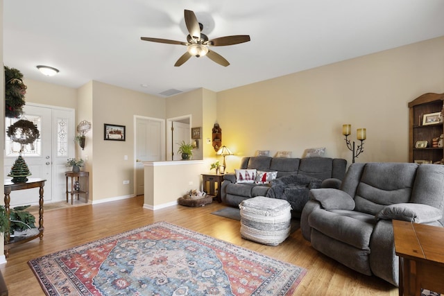 living room featuring light hardwood / wood-style flooring and ceiling fan