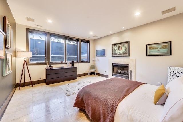 bedroom with light tile patterned floors and a premium fireplace