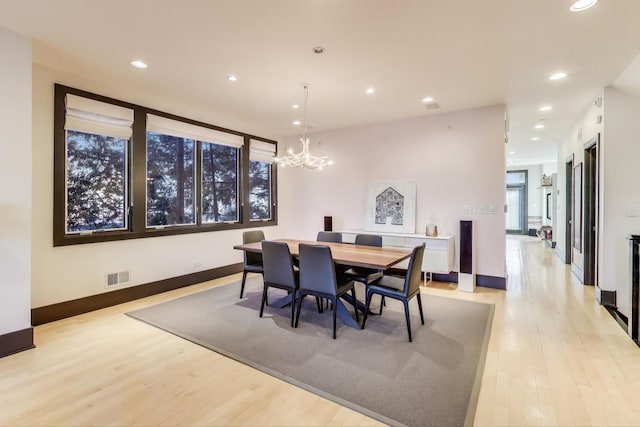 dining space featuring an inviting chandelier and light wood-type flooring