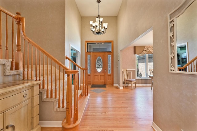 3430 Sandstone Ct, Lake In The Hills, IL 60156 - entryway with a towering ceiling, light wood-style floors, stairs, a chandelier, and baseboards