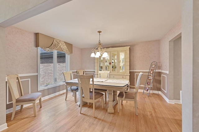 3430 Sandstone Ct, Lake In The Hills, IL 60156 - dining space with light wood-style flooring, a wainscoted wall, a chandelier, and baseboards
