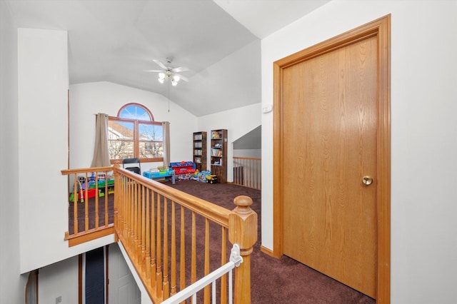 hall featuring lofted ceiling and dark colored carpet