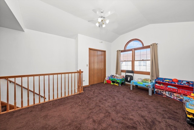 recreation room with lofted ceiling, ceiling fan, and dark colored carpet