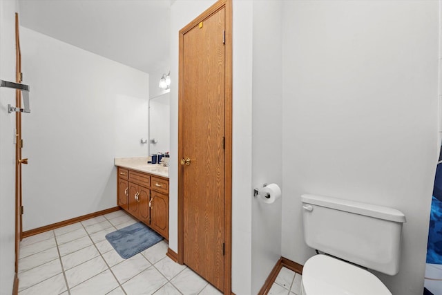 bathroom with toilet, vanity, and tile patterned flooring