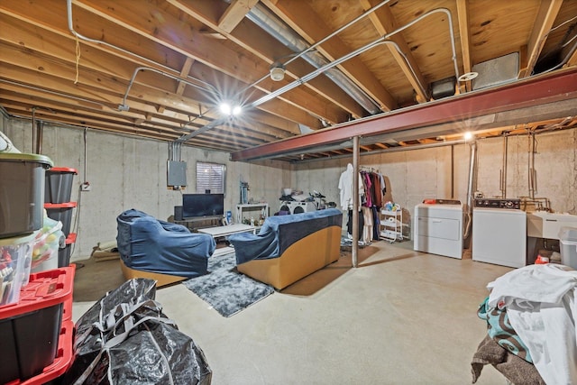 basement featuring electric panel, washer and dryer, and sink