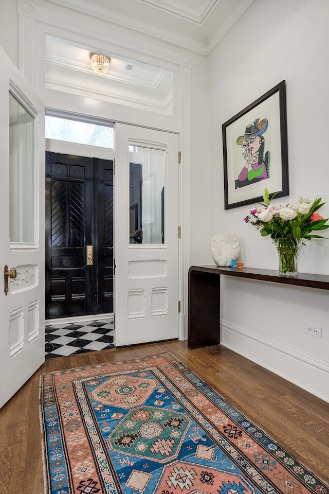 foyer entrance featuring dark hardwood / wood-style floors and ornamental molding