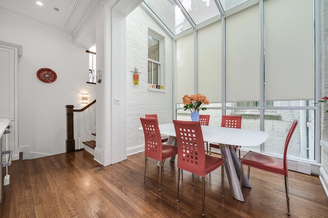 dining area with dark hardwood / wood-style floors, a skylight, and ornamental molding