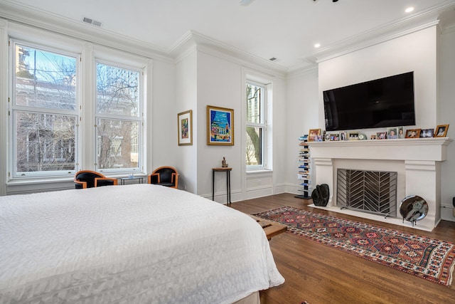 bedroom with multiple windows, crown molding, and hardwood / wood-style floors