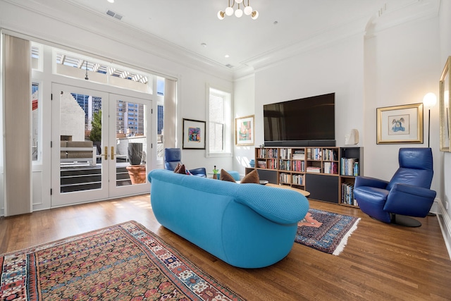 living room with hardwood / wood-style floors, crown molding, and french doors