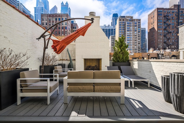 deck with an outdoor living space with a fireplace