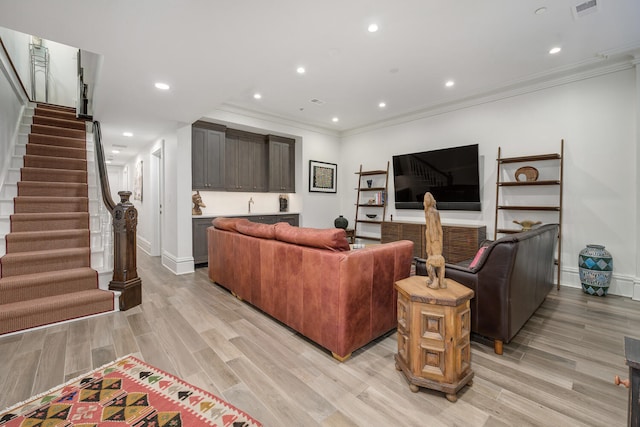 living room featuring ornamental molding and light hardwood / wood-style flooring