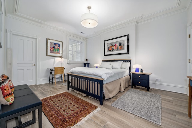 bedroom featuring light wood-type flooring and crown molding