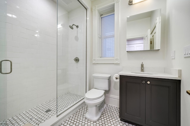 bathroom with tile patterned floors, vanity, toilet, and walk in shower