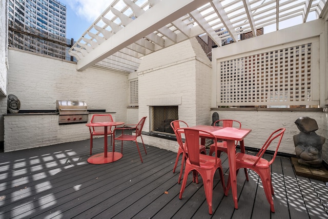 wooden terrace with a pergola, grilling area, area for grilling, and an outdoor brick fireplace