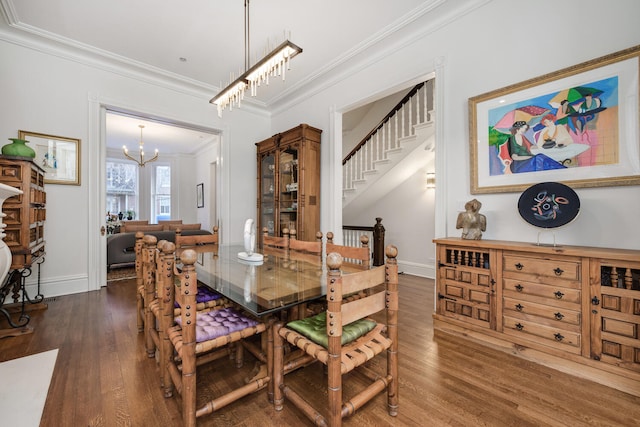 dining room with a chandelier, dark wood-type flooring, and ornamental molding