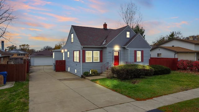 view of front of property featuring a lawn, a garage, and an outdoor structure