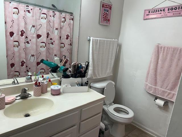 bathroom with tile patterned flooring, vanity, and toilet