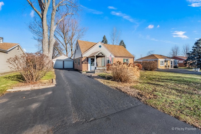 view of front of property with a porch, a garage, a front lawn, and an outdoor structure