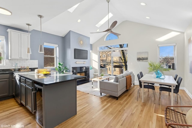 kitchen featuring decorative backsplash, ceiling fan, white cabinets, wine cooler, and hanging light fixtures